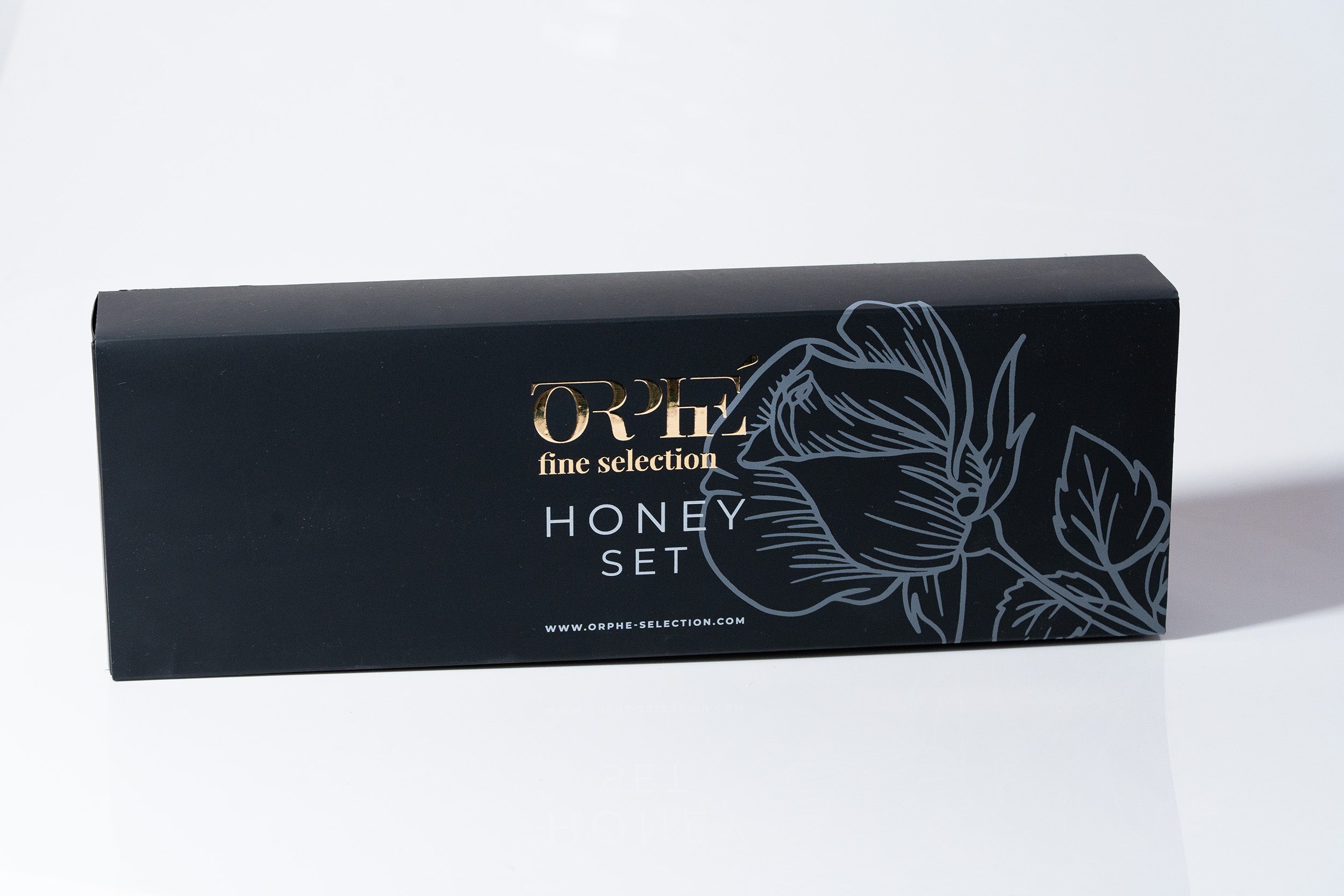 "Black box packaging with floral artwork and 'ORPE fine selection' branding on a white background, linked to honey purple and lavender syrup