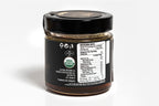 Clear glass jar topped with a black lid, featuring a prominent organic label with natural design elements. The jar is set against a clean white background, emphasizing its eco-friendly and organic qualities.