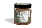 Clear glass jar containing an organic product, featuring a green label with eco-friendly design elements. The jar is set against a clean white background, emphasizing the natural and wholesome quality of the product.
