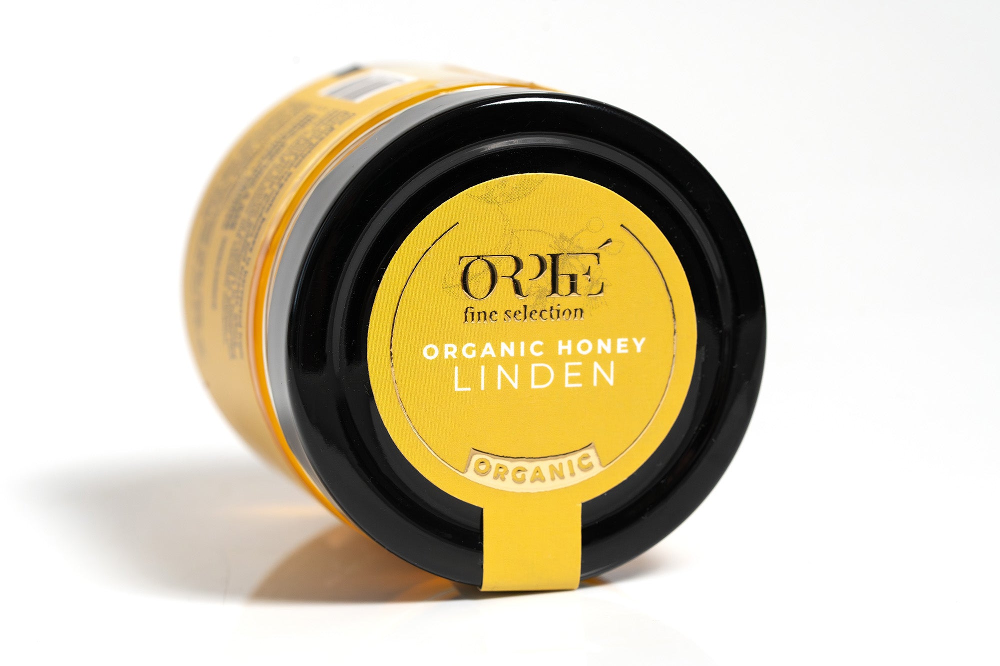"Orfe brand organic honey in a clear container with a bright yellow label, featuring clean branding and product details. The container is filled with rich golden amber honey and is photographed against a white background for a fresh, professional look.