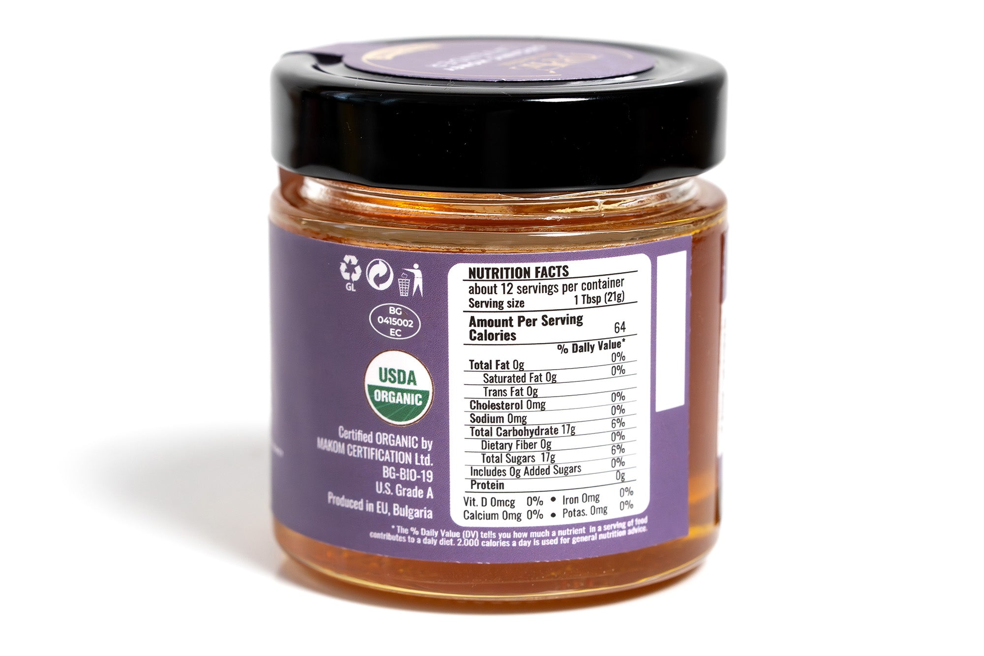 Clear glass jar of honey displaying the back side with a detailed nutrition label, showing product information and ingredients. The amber-colored honey is visible through the jar, and the product is photographed on a plain white background for a clean, professional look.