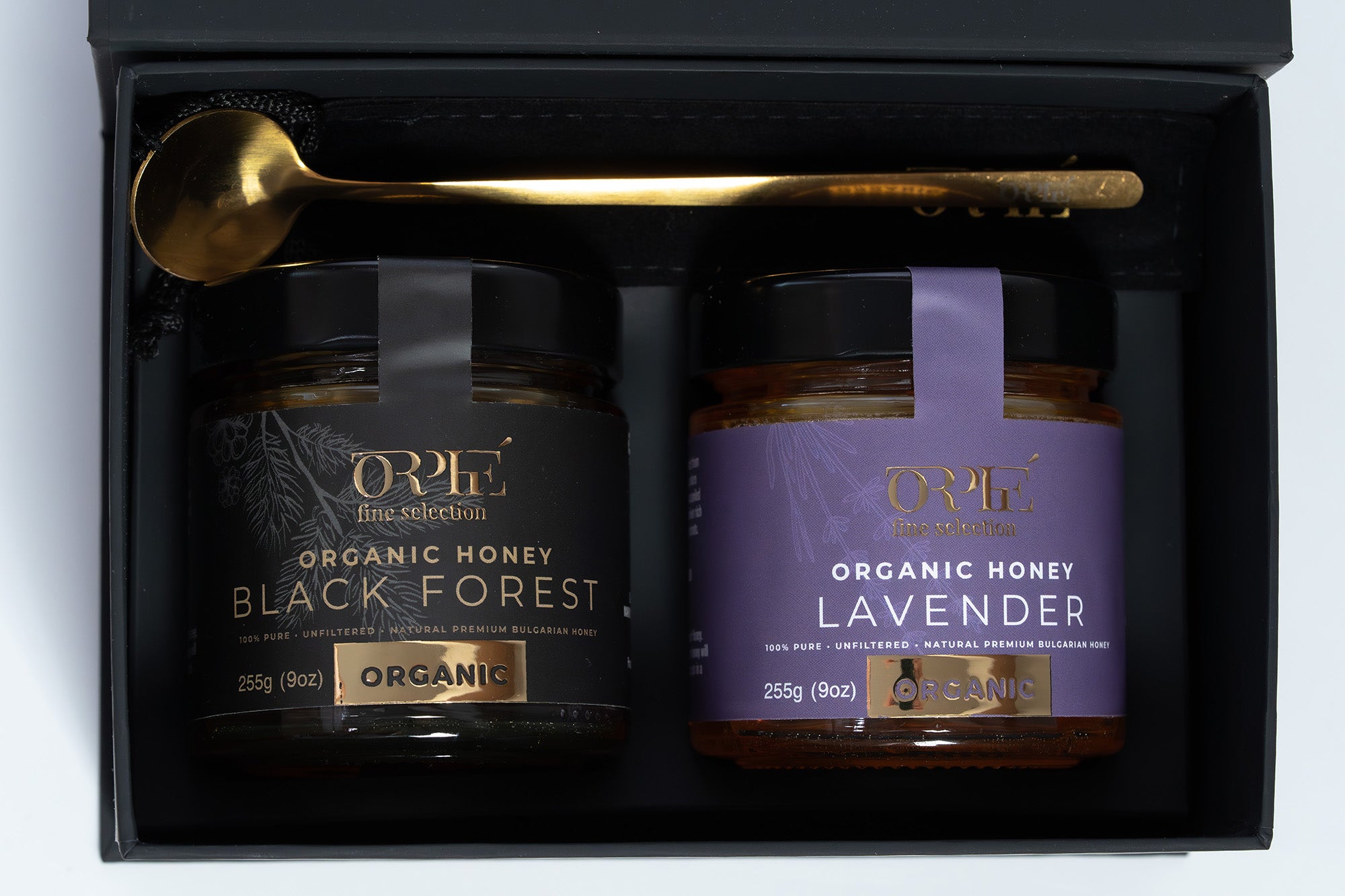 Orphe fine selection gift box with Two jars of organic honey, one labeled 'Black Forest' and the other 'Lavender', in a black gift box with a gold spoon.